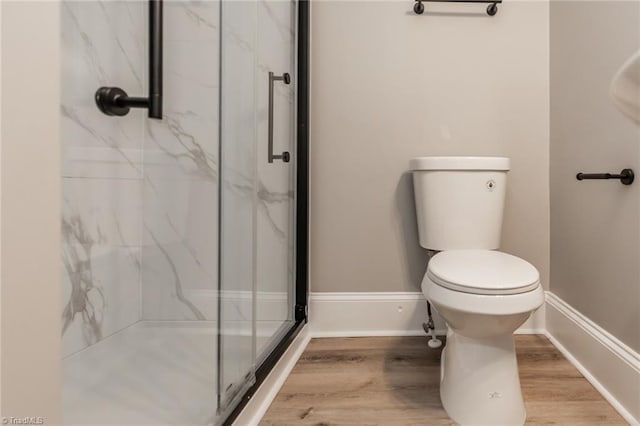 bathroom with a shower with door, wood-type flooring, and toilet