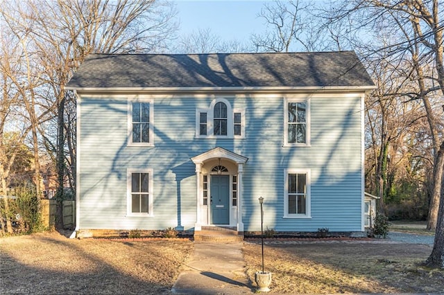 colonial-style house featuring a front lawn