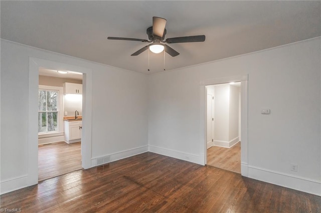 unfurnished room featuring hardwood / wood-style flooring, ceiling fan, and sink