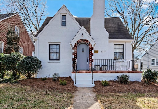 english style home with covered porch