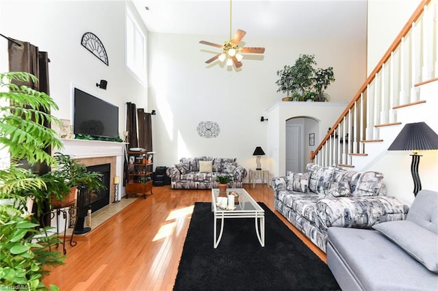 226 Marshview Cir, Angier, NC 27501 - living area featuring stairway, a towering ceiling, wood finished floors, a fireplace, and ceiling fan