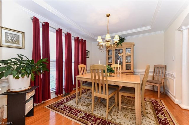 226 Marshview Cir, Angier, NC 27501 - dining room featuring light wood-style flooring, crown molding, a notable chandelier, and decorative columns