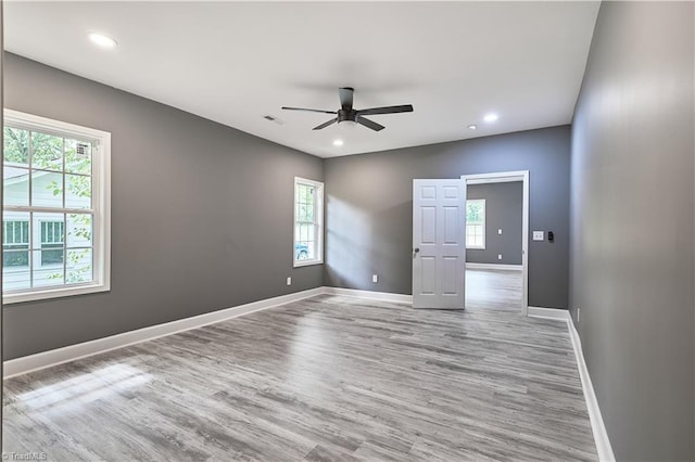 unfurnished room with light hardwood / wood-style flooring, a wealth of natural light, and ceiling fan