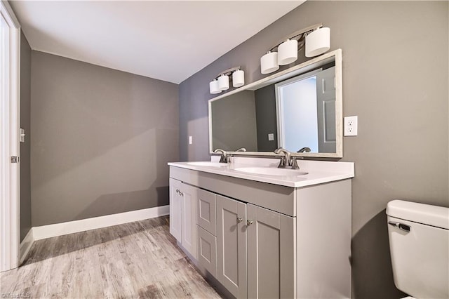 bathroom featuring vanity, wood-type flooring, and toilet