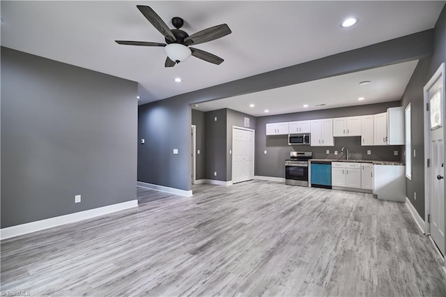 kitchen featuring white cabinetry, sink, light hardwood / wood-style flooring, and appliances with stainless steel finishes