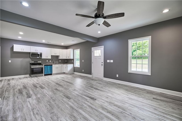 kitchen featuring stainless steel appliances, ceiling fan, sink, white cabinets, and hardwood / wood-style floors