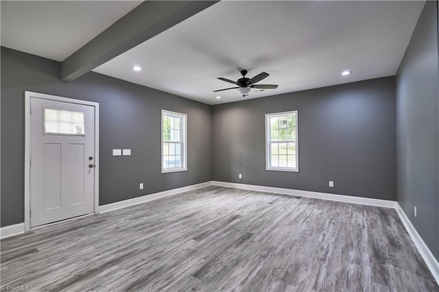 entrance foyer featuring ceiling fan, beam ceiling, light hardwood / wood-style floors, and a wealth of natural light