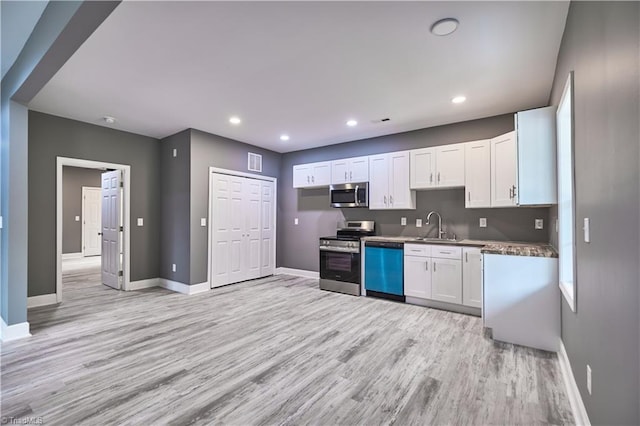 kitchen with white cabinets, sink, light wood-type flooring, and stainless steel appliances