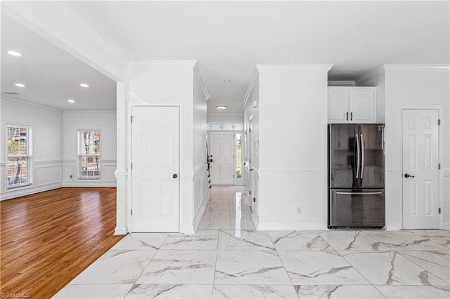 kitchen with white cabinetry, fridge, and crown molding