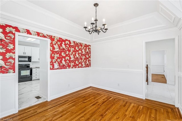 interior space featuring ornamental molding, an inviting chandelier, and light hardwood / wood-style floors