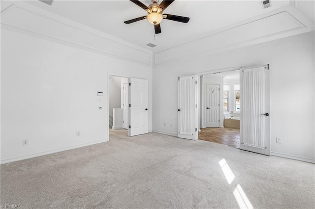 unfurnished bedroom featuring light carpet, ensuite bath, and ceiling fan