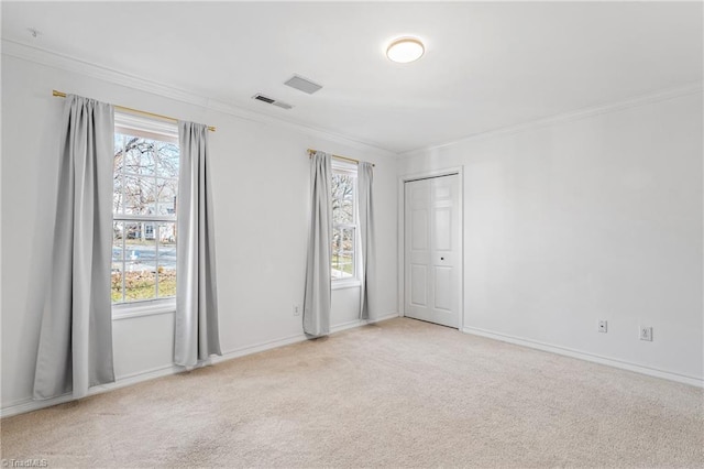 carpeted spare room with crown molding and a healthy amount of sunlight