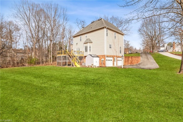 back of house featuring a yard, a garage, and a deck