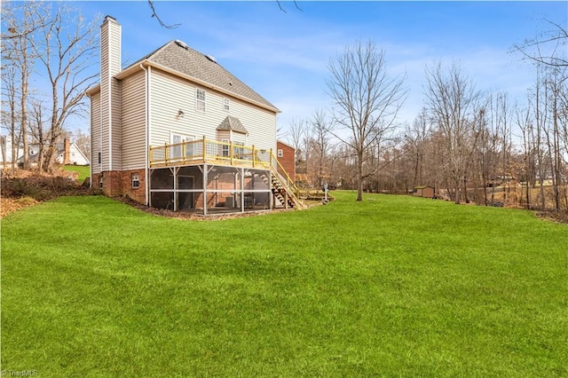 rear view of house with a wooden deck, a sunroom, and a lawn