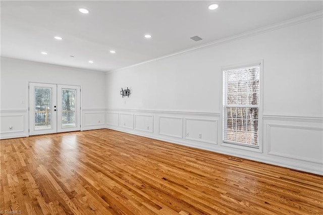 unfurnished room featuring crown molding, french doors, and light wood-type flooring