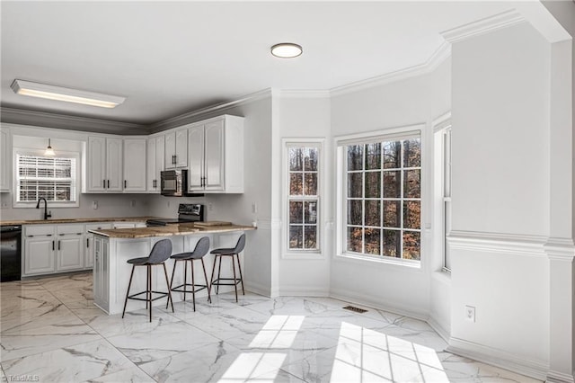 kitchen featuring a breakfast bar, ornamental molding, kitchen peninsula, white cabinets, and black appliances