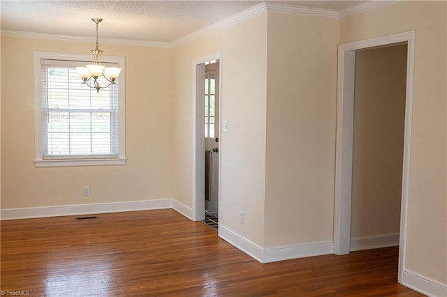 empty room with visible vents, baseboards, a notable chandelier, and wood finished floors