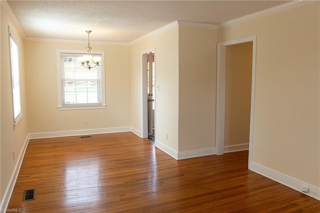 unfurnished room with a notable chandelier, wood finished floors, visible vents, and a textured ceiling