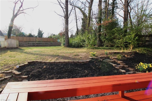 view of yard with a storage unit, an outbuilding, and fence