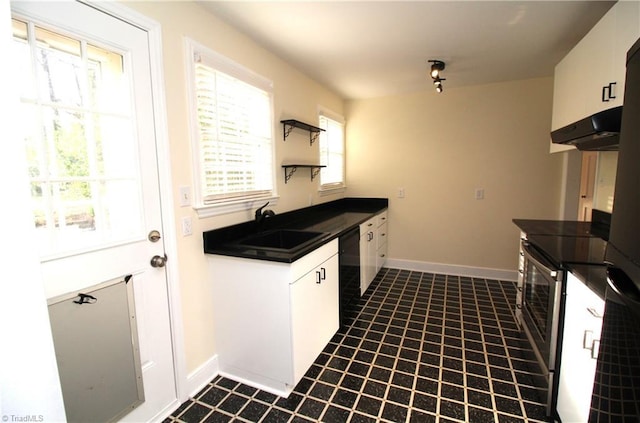 kitchen featuring a sink, dark countertops, stainless steel electric range, baseboards, and dishwasher