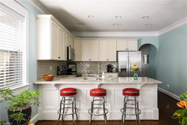 26 Vintage Ave, Winston-Salem, NC 27127 - kitchen with a peninsula, dark wood-style flooring, stainless steel appliances, baseboards, and backsplash