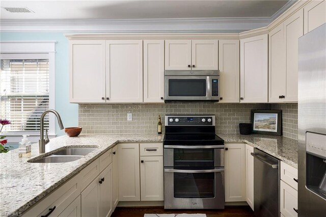 26 Vintage Ave, Winston-Salem, NC 27127 - kitchen featuring ornamental molding, visible vents, a sink, stainless steel appliances, and decorative backsplash