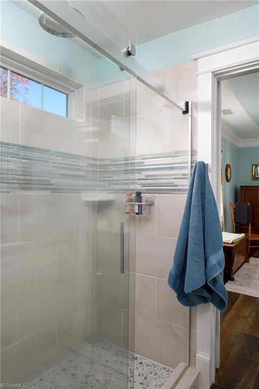 26 Vintage Ave, Winston-Salem, NC 27127 - bathroom with visible vents, crown molding, a stall shower, and wood finished floors