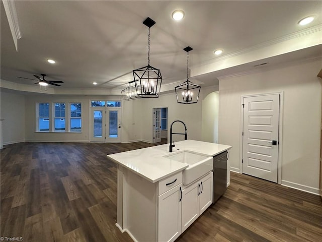 kitchen with pendant lighting, black dishwasher, light countertops, open floor plan, and a kitchen island with sink