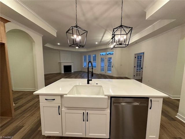 kitchen with a sink, white cabinets, open floor plan, light countertops, and an island with sink