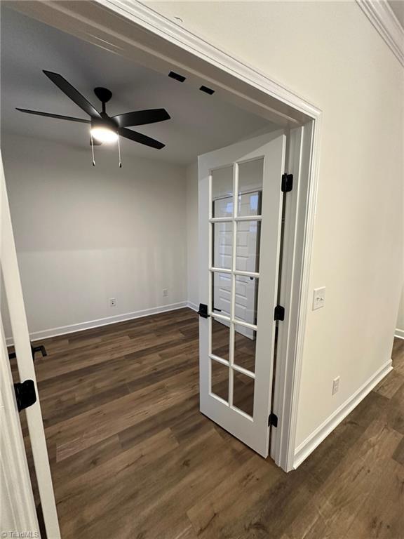 spare room with dark wood-type flooring, french doors, ceiling fan, and baseboards