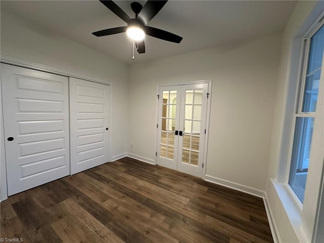 unfurnished bedroom featuring baseboards, dark wood finished floors, a ceiling fan, french doors, and a closet