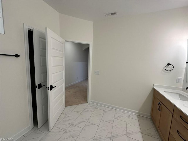 bathroom featuring marble finish floor, vanity, visible vents, and baseboards