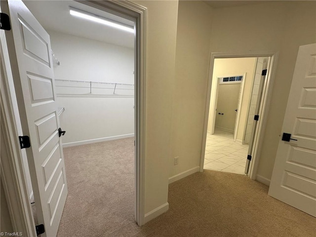 hall featuring light carpet and baseboards