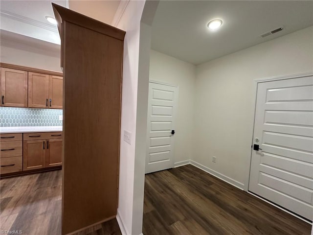 interior space featuring dark wood-type flooring, visible vents, and baseboards