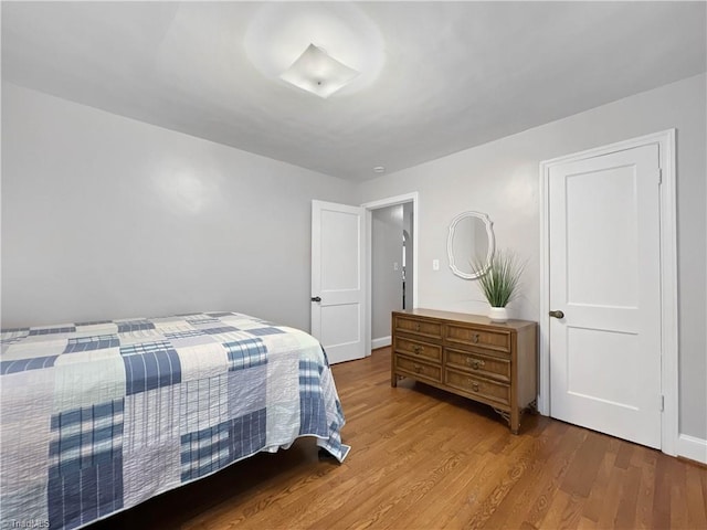 bedroom with baseboards and wood finished floors
