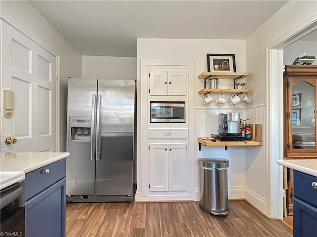 kitchen with dark wood-type flooring, light countertops, appliances with stainless steel finishes, and blue cabinetry