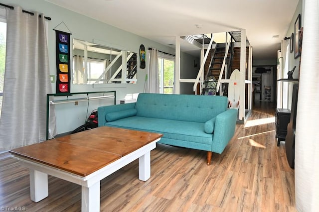 living area featuring wood finished floors and stairway
