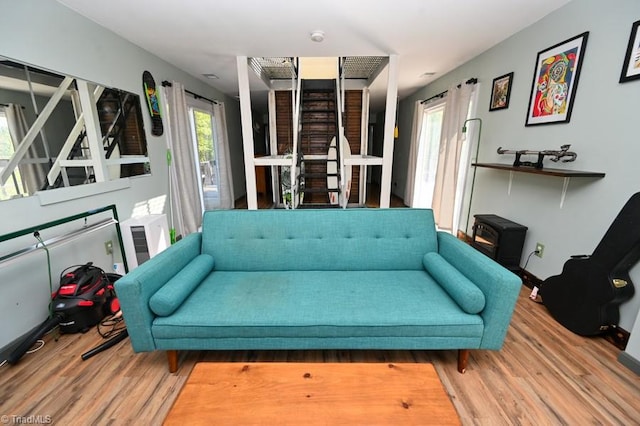 living room featuring stairs, wood finished floors, and a wall unit AC