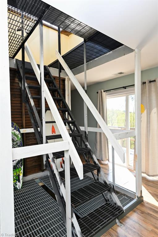 stairway with wood finished floors and visible vents