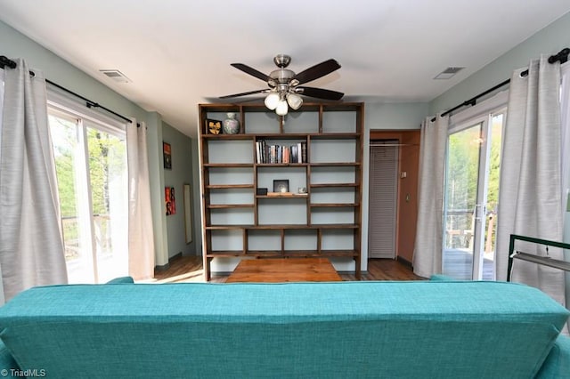 bedroom featuring wood finished floors, visible vents, access to outside, and multiple windows