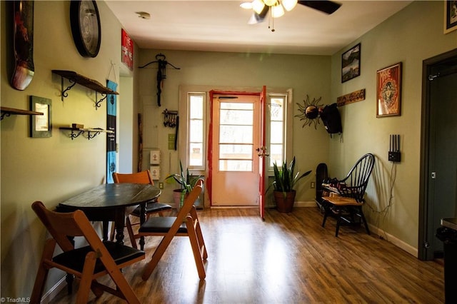 dining space featuring baseboards, a ceiling fan, and wood finished floors