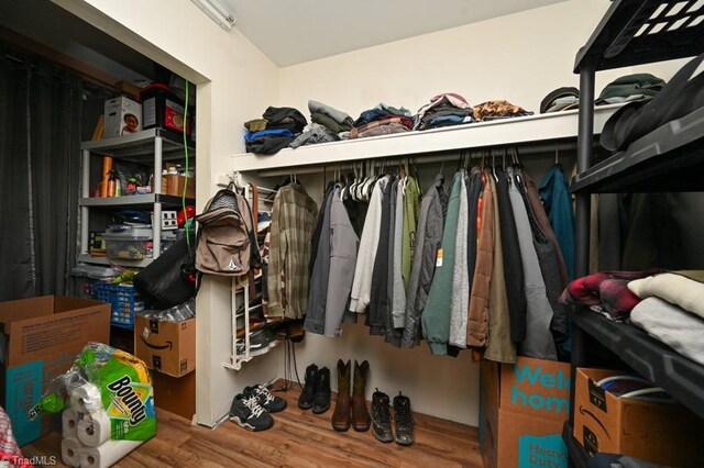 walk in closet with wood finished floors
