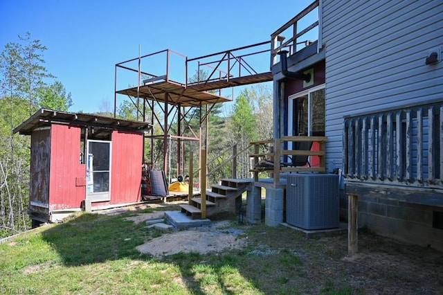 exterior space with central AC, an outbuilding, a balcony, and a storage shed