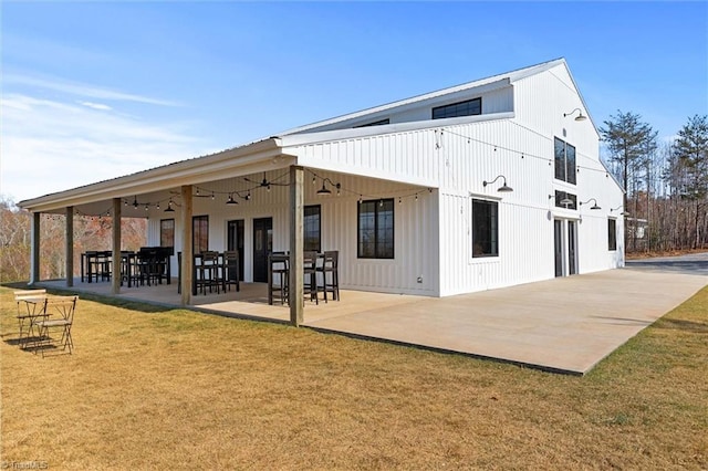 back of property with a patio and a lawn