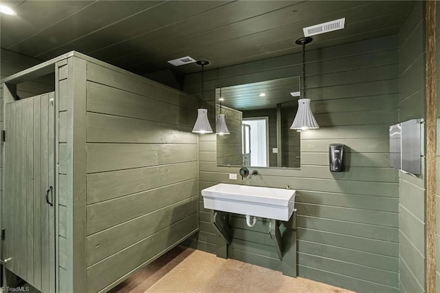 bathroom with sink and wooden walls