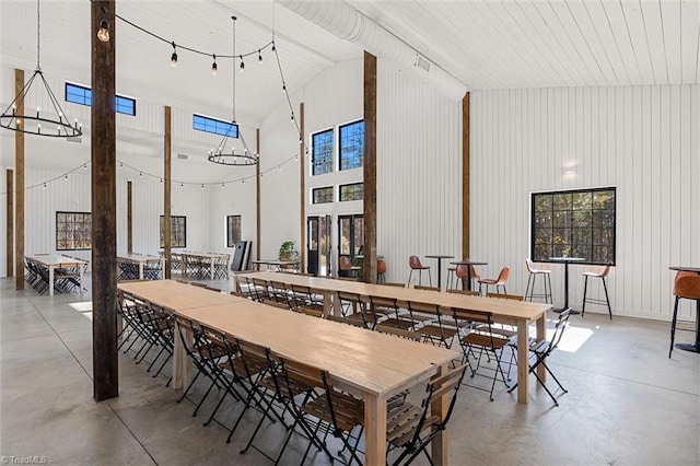 dining space featuring concrete flooring and high vaulted ceiling