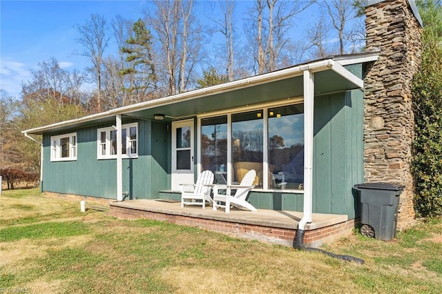 rear view of property featuring a lawn