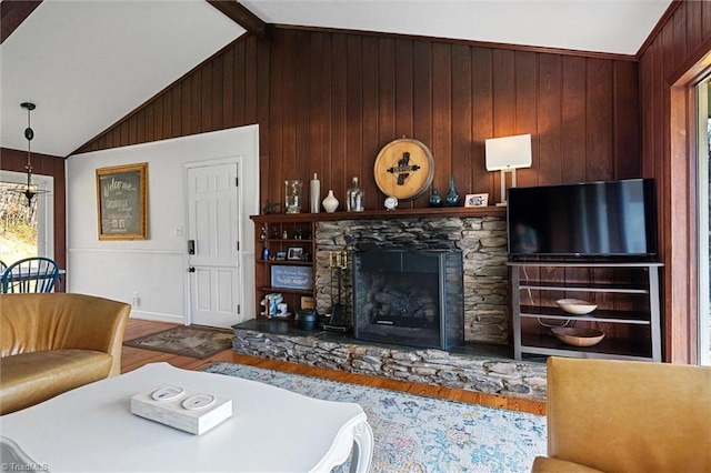 living room featuring wood-type flooring, lofted ceiling with beams, a stone fireplace, and wooden walls