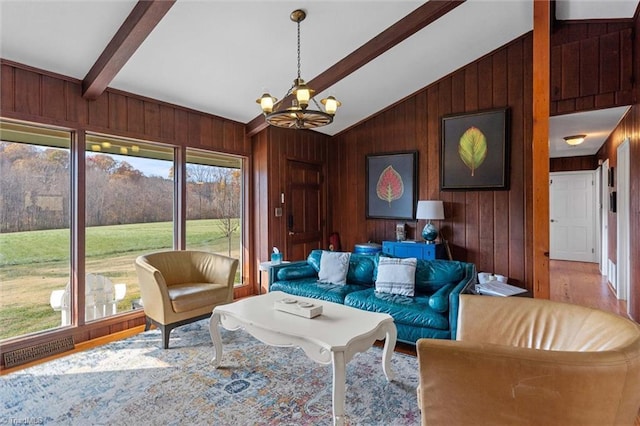 living room featuring a chandelier, wooden walls, lofted ceiling with beams, and wood-type flooring