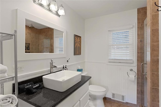 bathroom with tile patterned flooring, vanity, toilet, and an enclosed shower